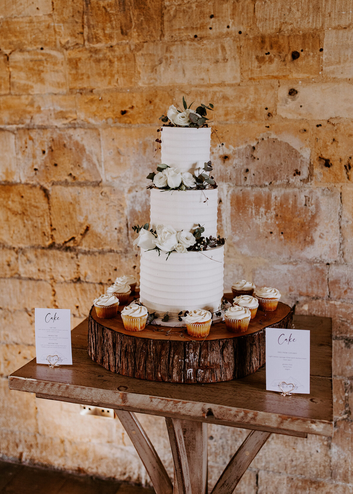 Textured white wedding cake with garlands of flowers at Lapstone Barn