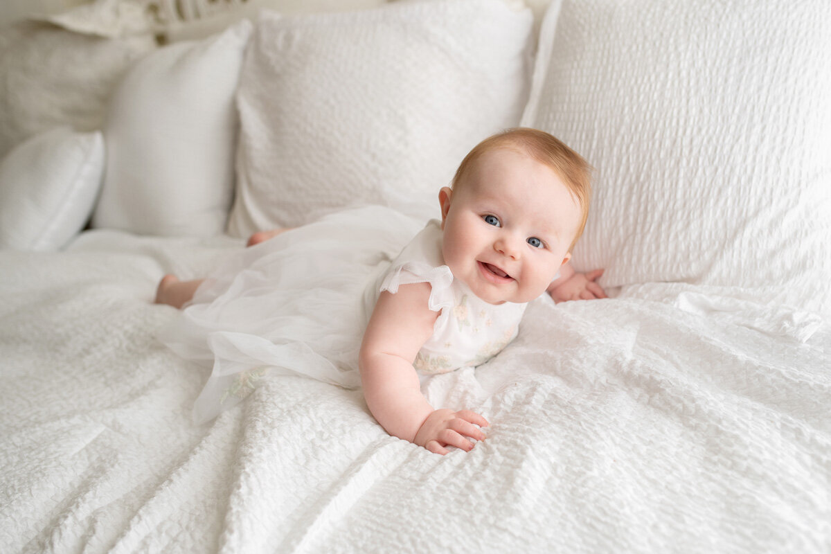 Family session of little girl laying on bed