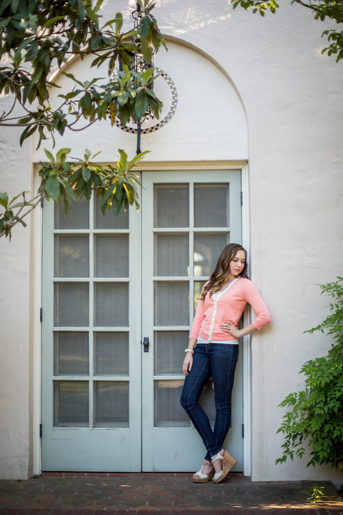 high school senior girl hand hip standing by door taken by San Antonio senior photographer