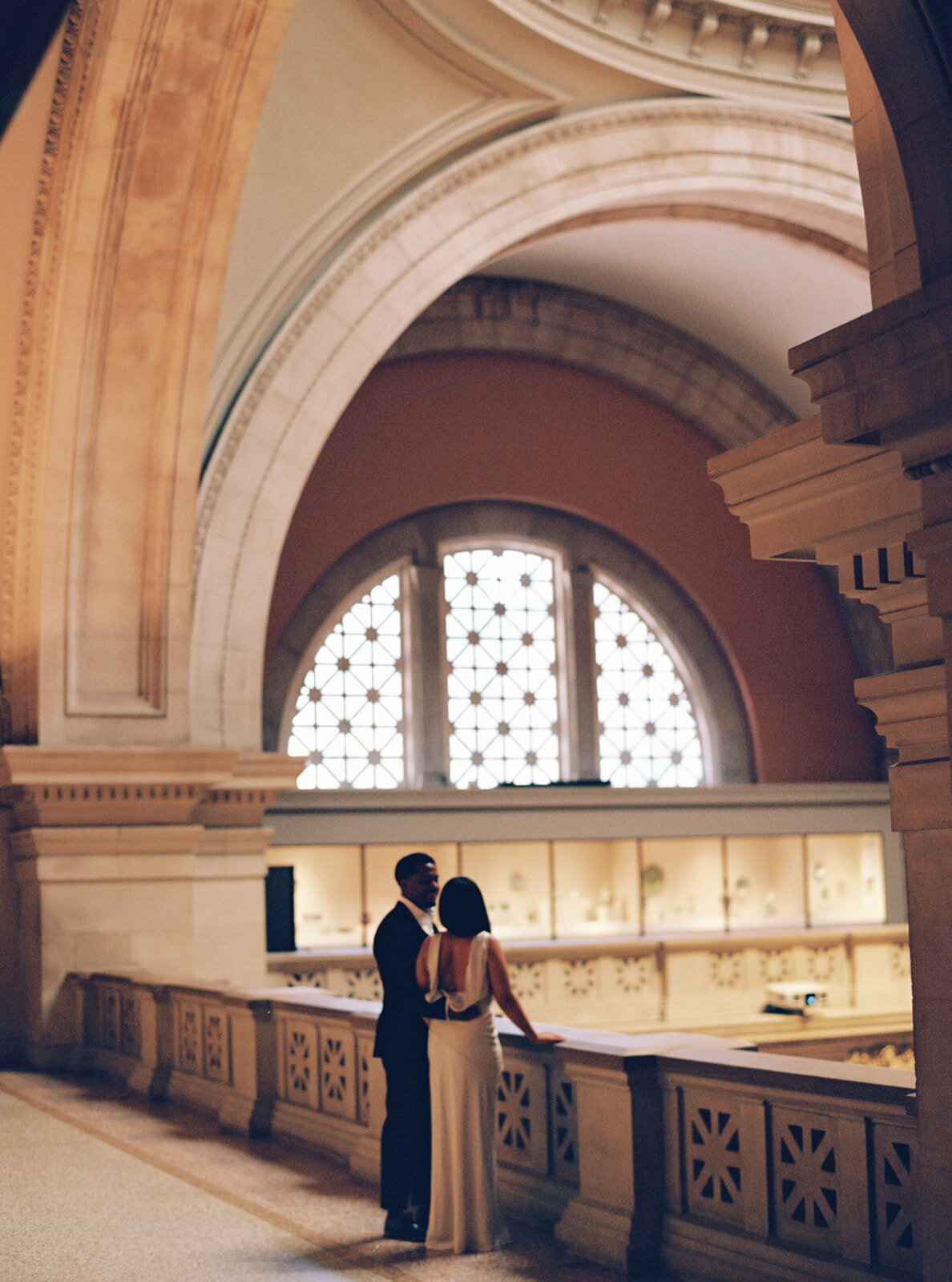couple standing around an interior balcony at the MET in manhattan