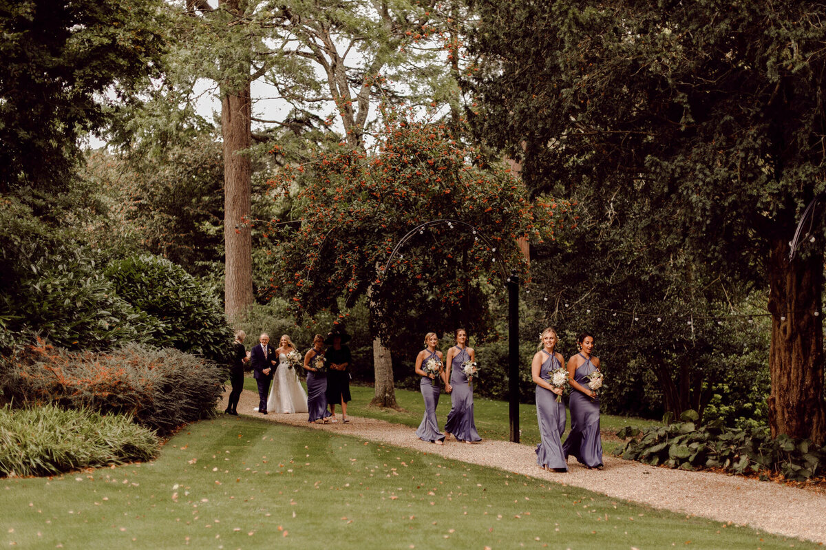 Bridesmaids walking down garden path