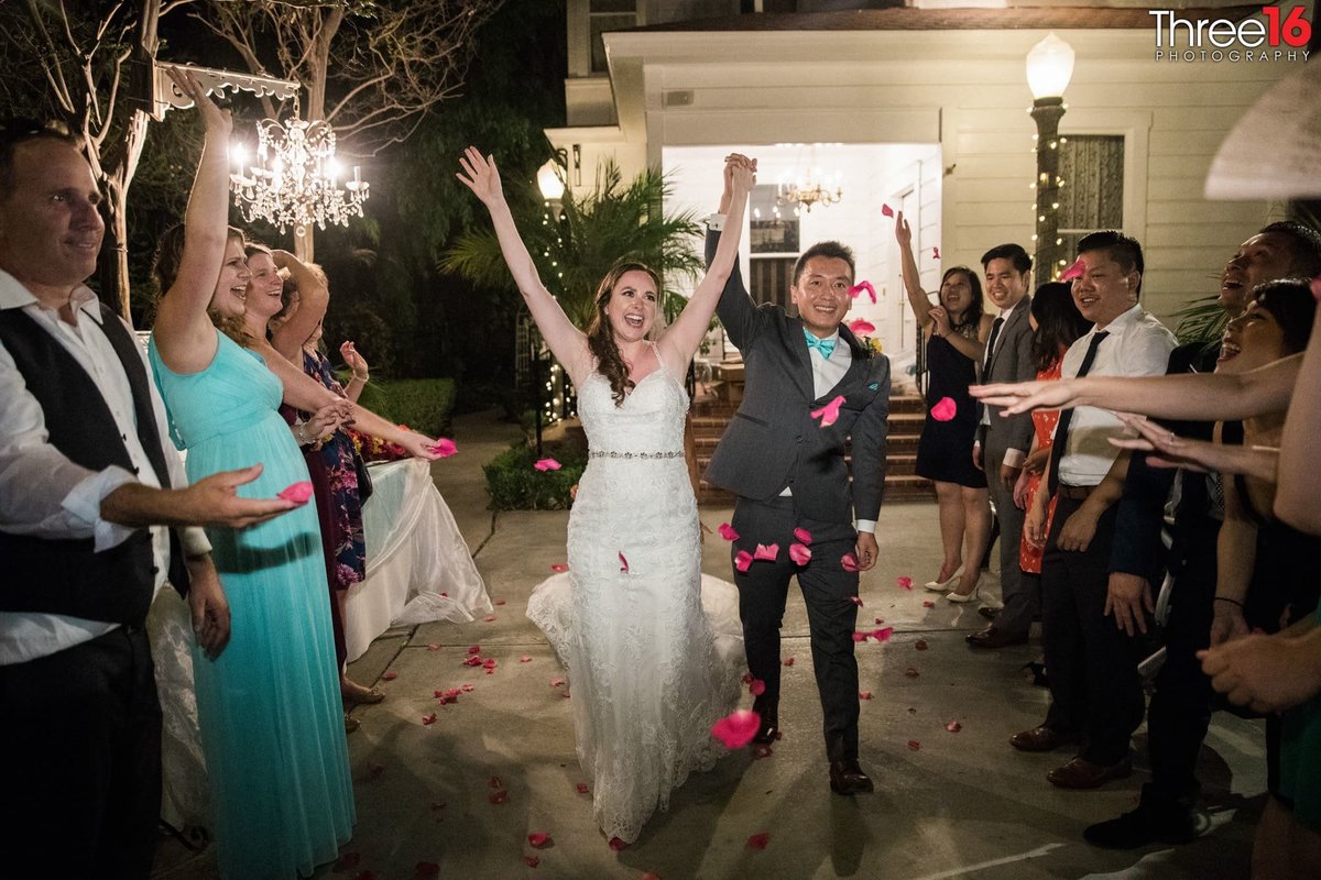 Newly married couple celebrates as they walk through lines of guests