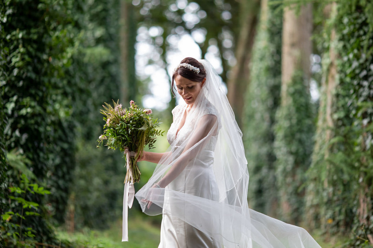 Bride between trees at Coombe Trenchard Devon
