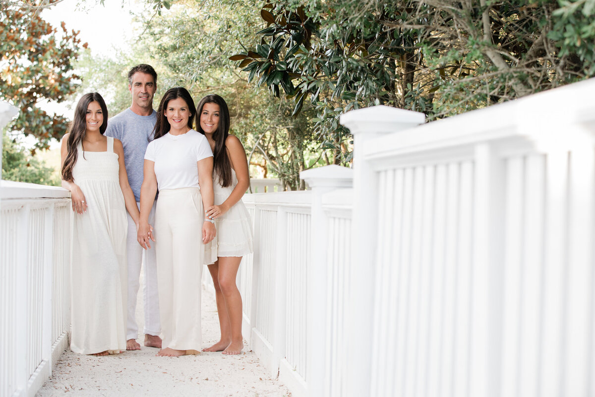 A small family standing on a sandy path smiling