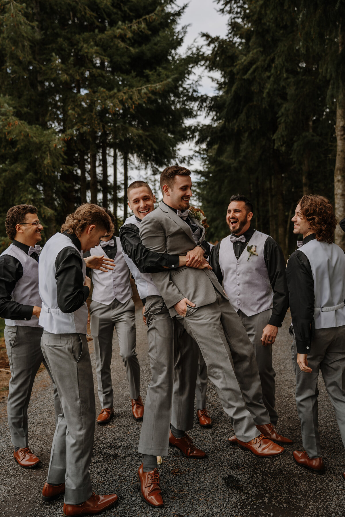 Group of groomsmen holding groom in the air