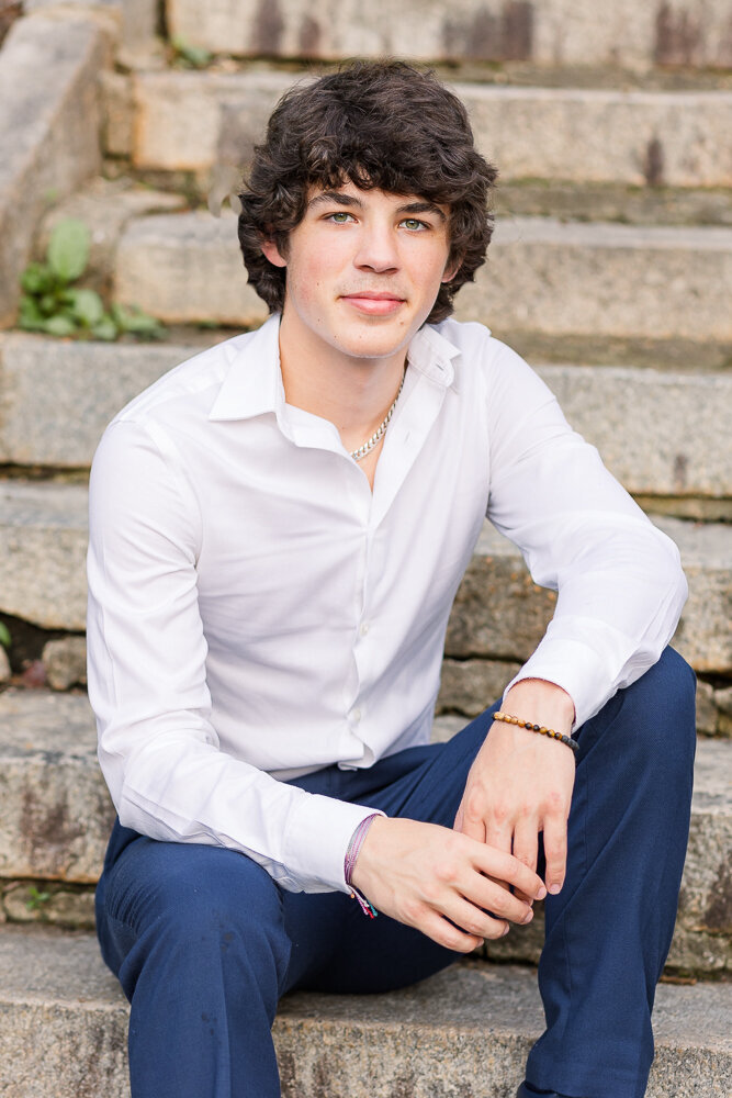 Senior class boy sitting on a rustic steps in Wake Forest, NC.