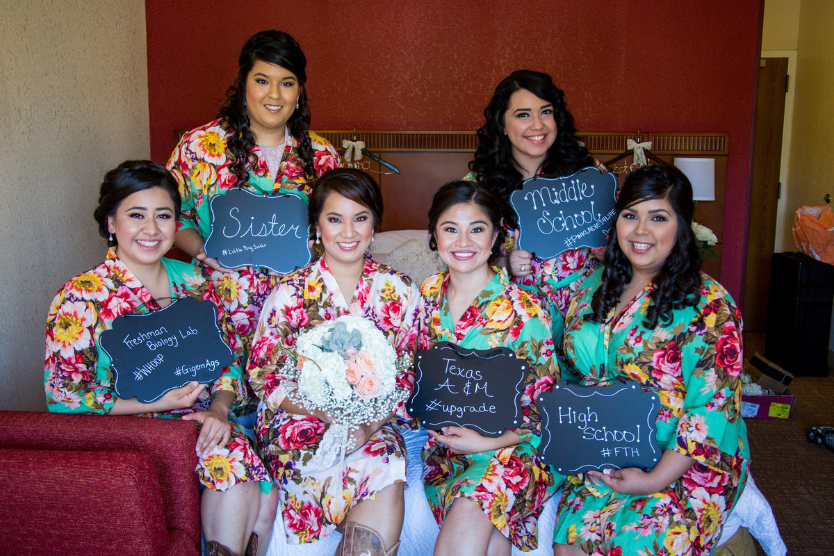 Bride and Bridesmaids holding prop signs during getting ready for wedding ceremony at Mission Concepcion