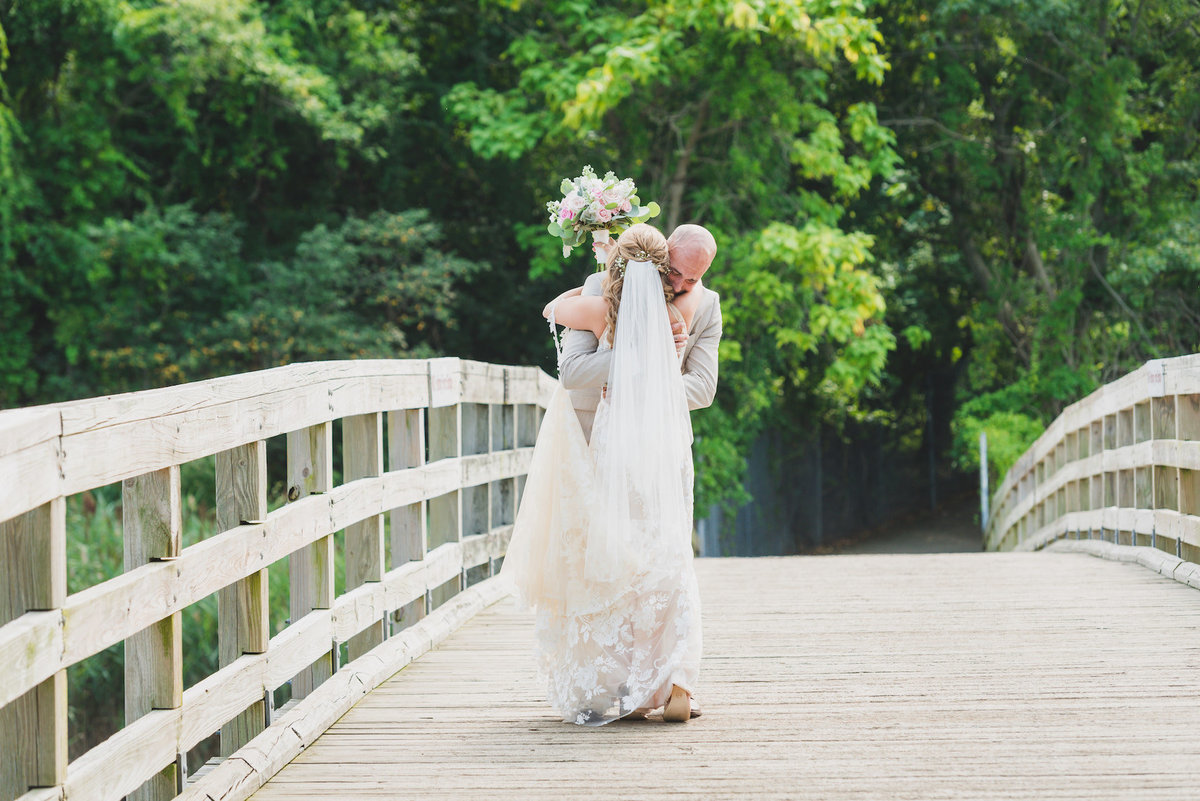 photo of bride and groom hugging on the bridge from wedding at Pavilion at Sunken Meadow