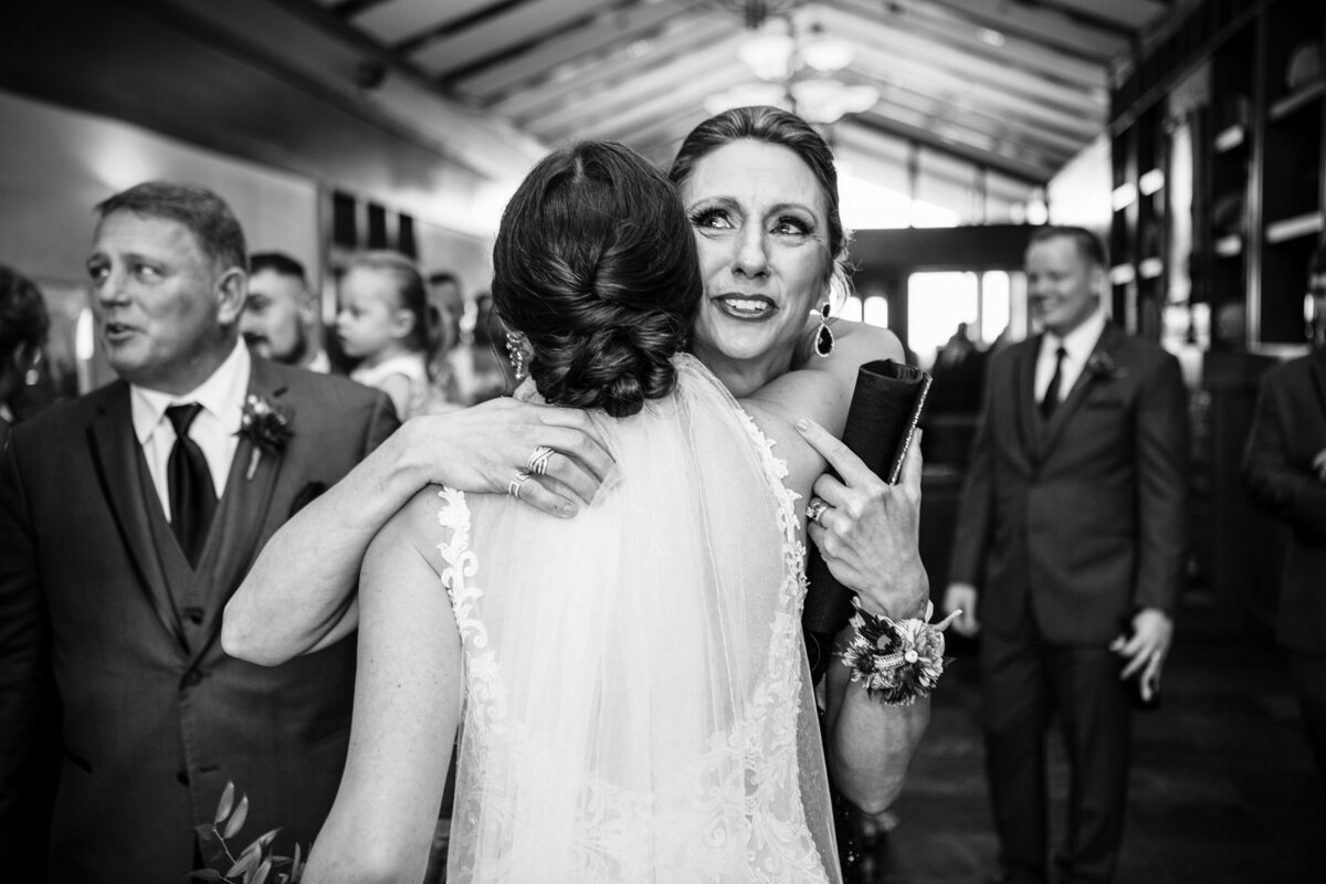 Bride hugs mom after wedding.