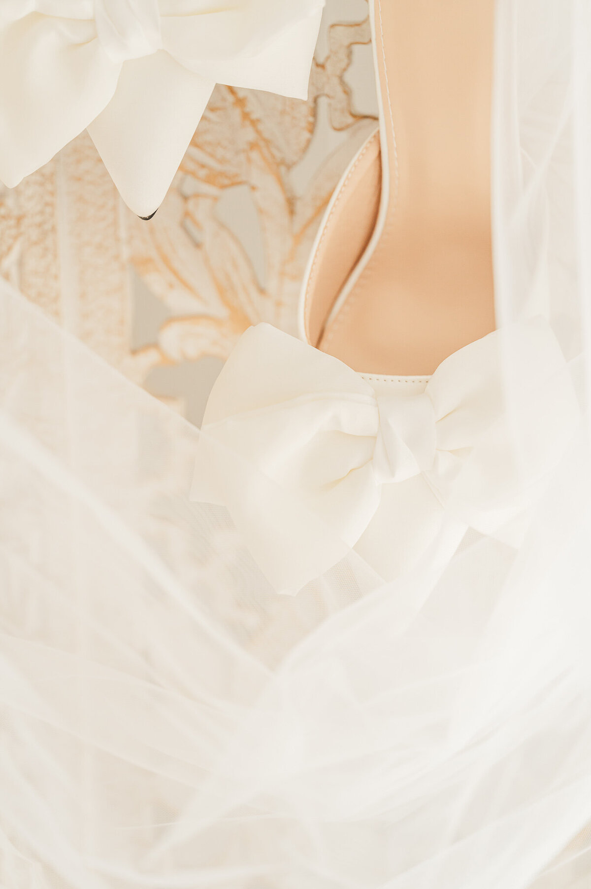 Warm romantic detail shot of a bride's wedding shoes and wedding veil by JoLynn Photography