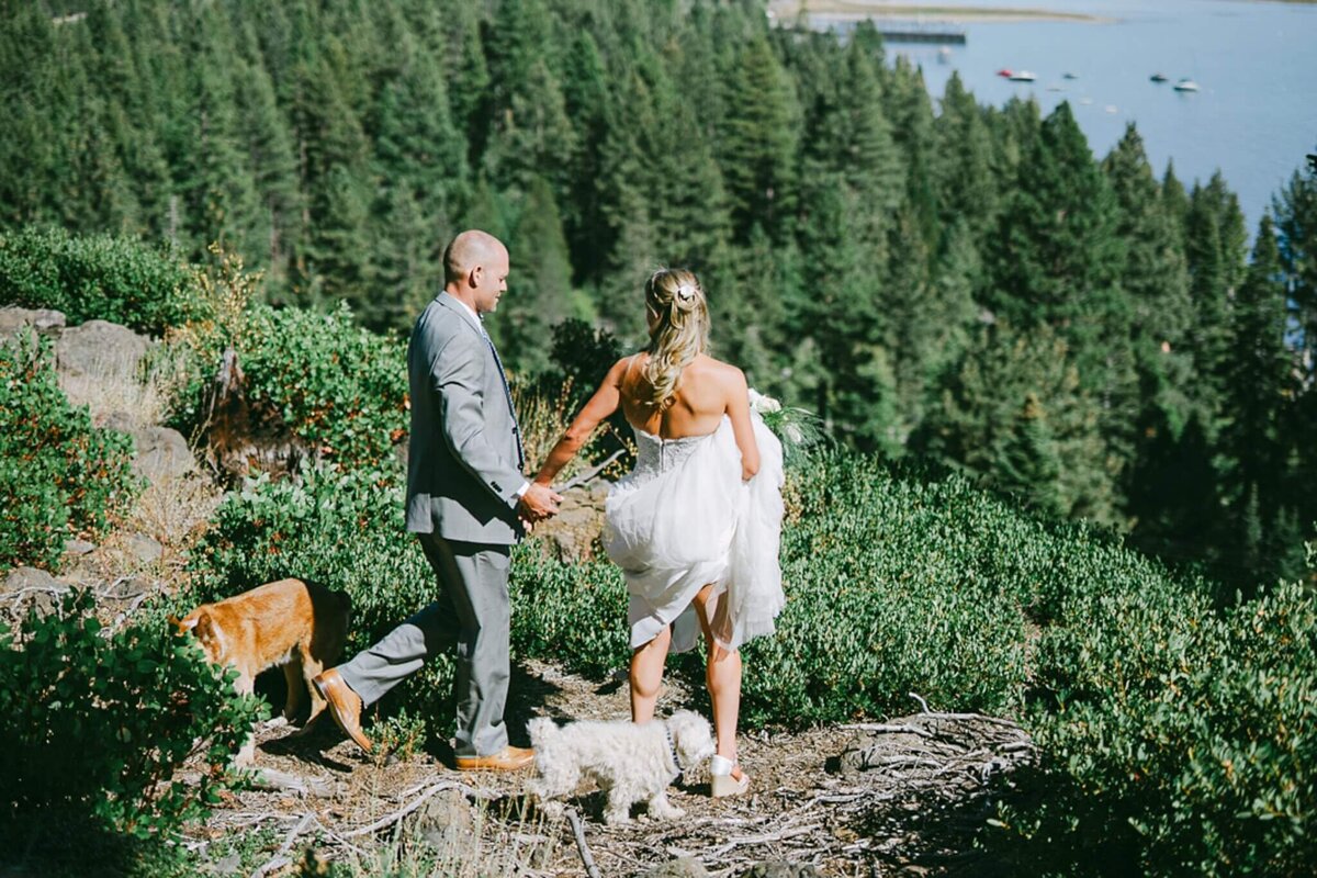 Couple with their two dogs looking at Lake Tahoe perched high in Tahoe city, california