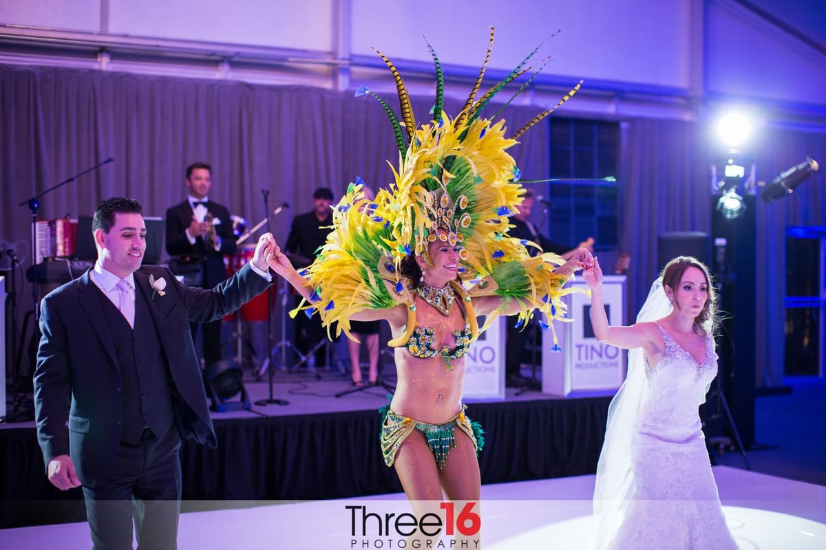 A Mayan dancer dances with the Bride and Groom during the wedding reception at the Hotel Maya in Long Beach, CA