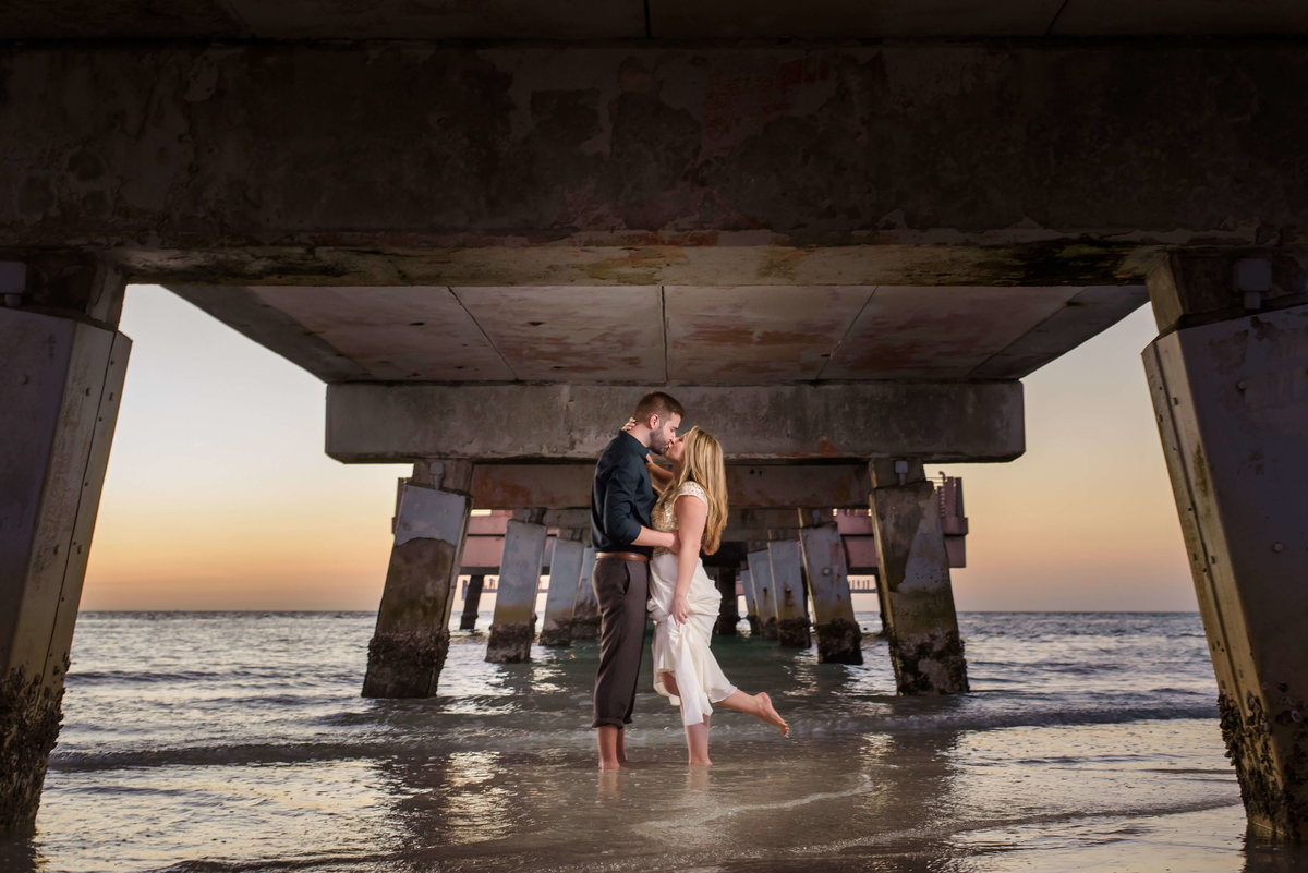 Couple share a kiss under the dock of fort desoto national monument