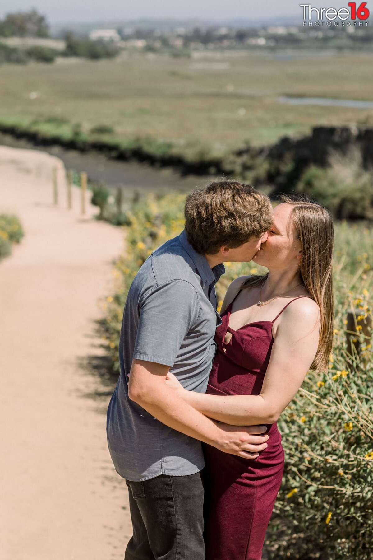 Engaged couple stop for a smooch during their engagement shoot