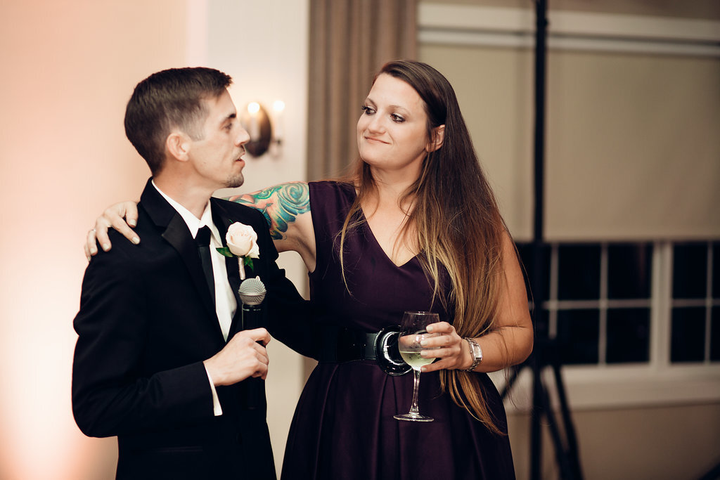 Wedding Photograph Of Groom in Black Suit And Woman In Violet Dress Talking To Each Other Los Angeles