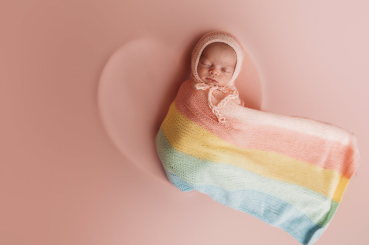 Rainbow baby posed in a heart bowl for her Newborn Portrait Session in Asheville, NC.