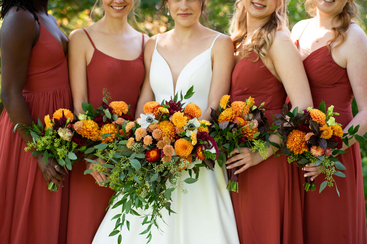 a closeup photo showing the details of a bride's fall bouquet and the bridesmaids' bouquet.  Taken outside at Strathmere wedding venue in Ottawa by JEMMAN Photography