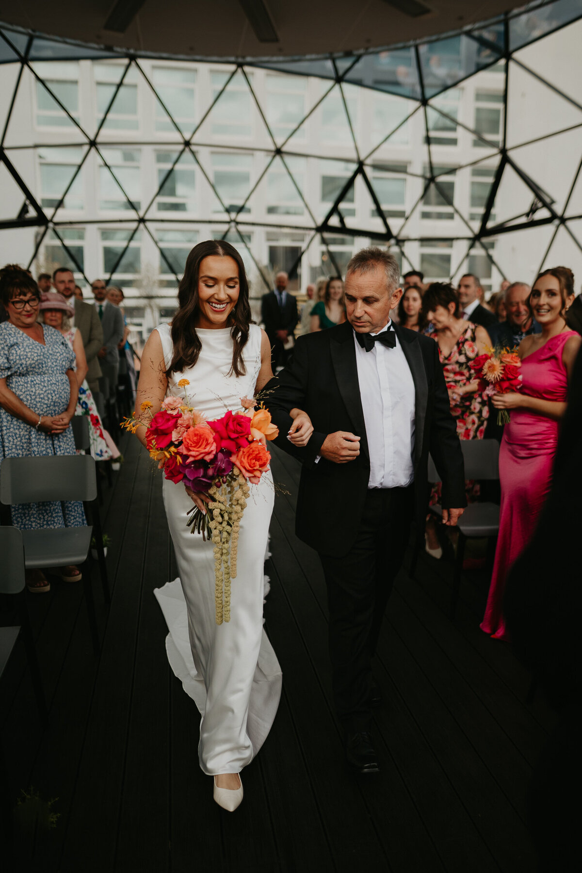 Bride and her father walk down the aisle at her wedding at The Dome at ABC buildings in Manchester. 