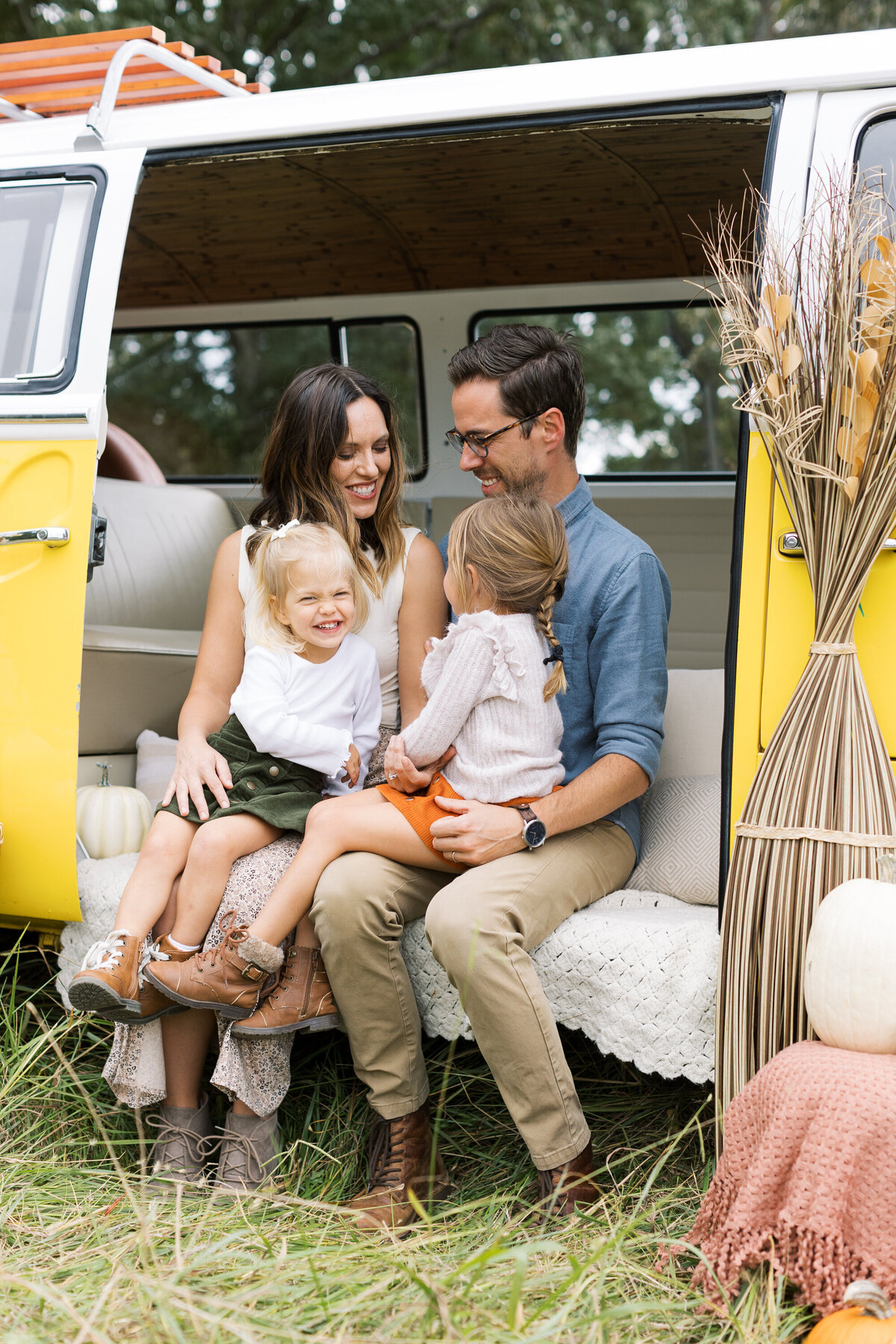 family sitting on a yellow bus at fall mini session