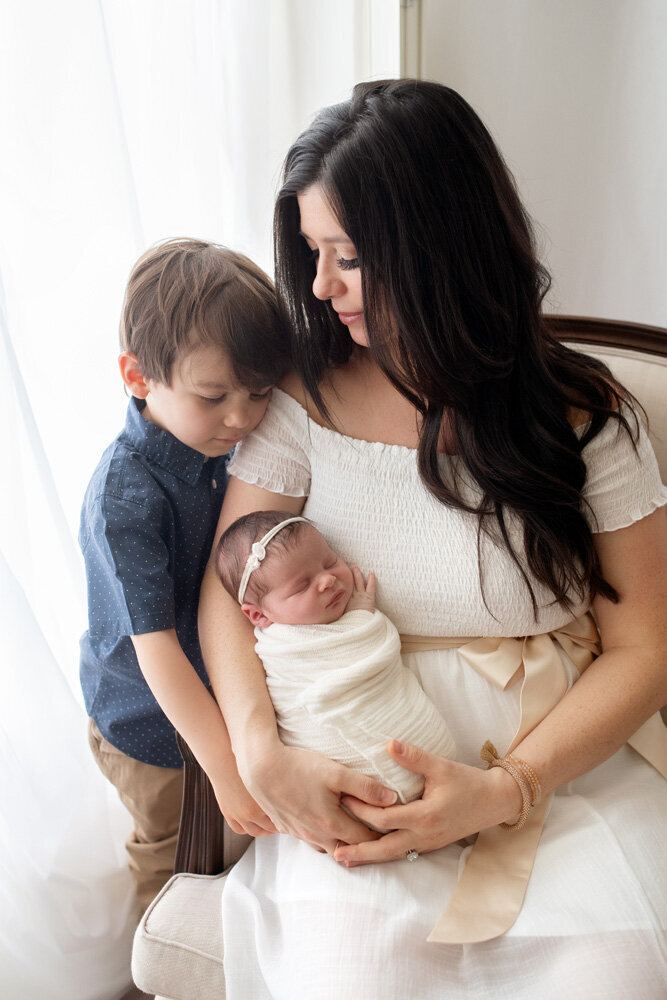 Newborn session of baby girl with older brother and mother