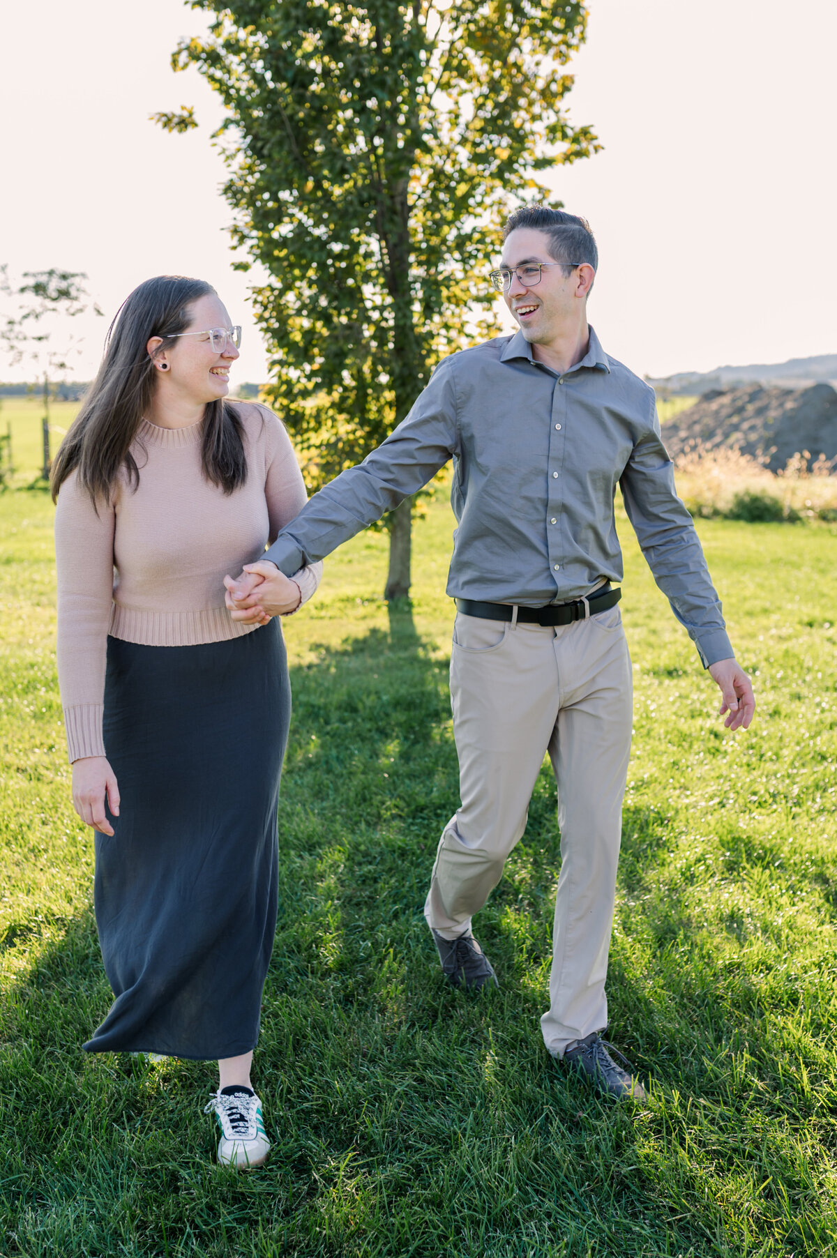 Couple-walking-and-lookinh-at-each-other-in-green-field