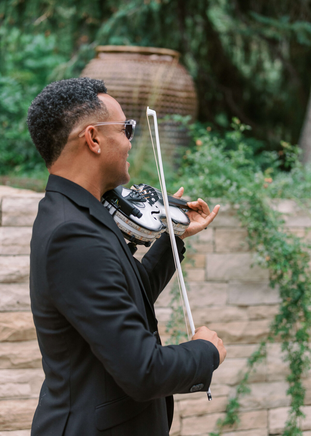 Violinist serenades the guests during the cocktail hour at a garden wedding