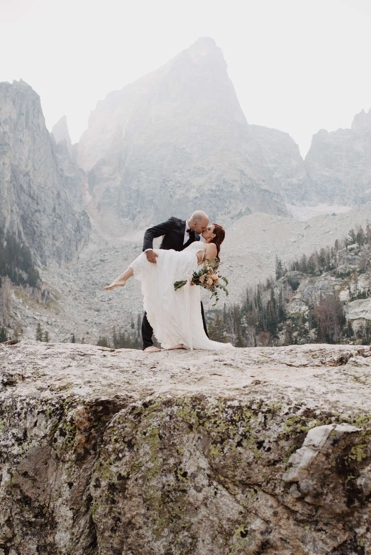 Jackson Hole elopement photographer captures couple kissing on boulder