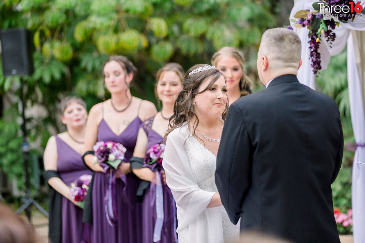 Bride looks at her Groom as he says his vows to her at the altar