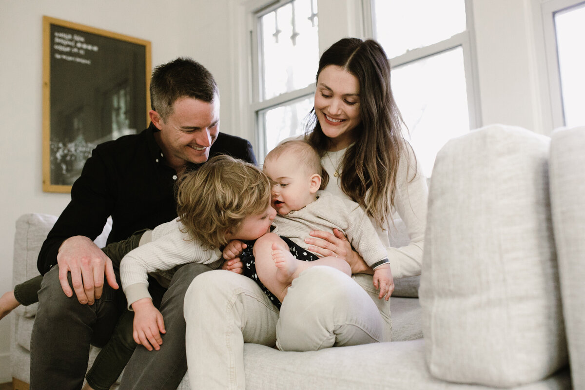 Family on couch with toddler and baby at Austin family photo session