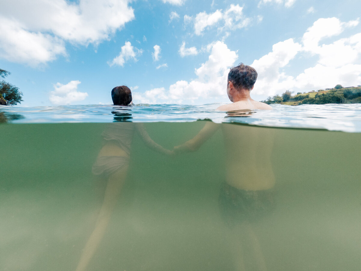 father and daughter holding hands while jumping waves at the beach during a family photo session at crab cove beach.