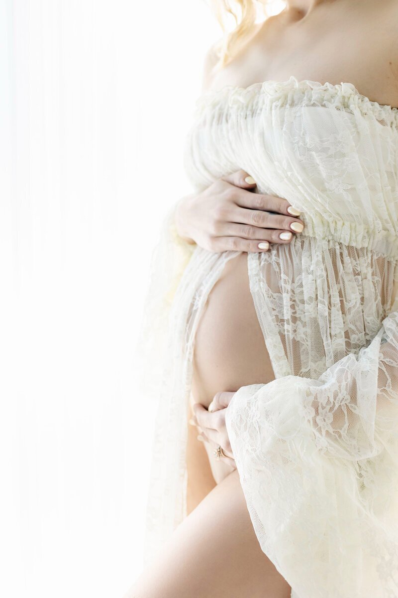 Close up of baby bump with lace top by maternity photographer nj
