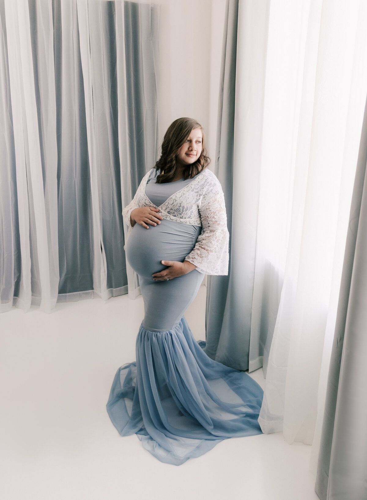Bright white backlit photo of a pregnant mother. Studio portrait by Diane Owen