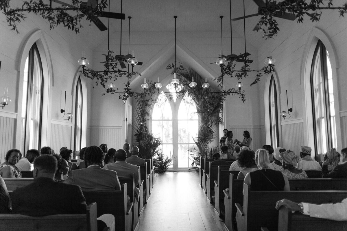 Black and white photo of the wedding chapel, guests seated,  in Montage at Palmetto Bluff. Destination wedding image by Jenny Fu Studio