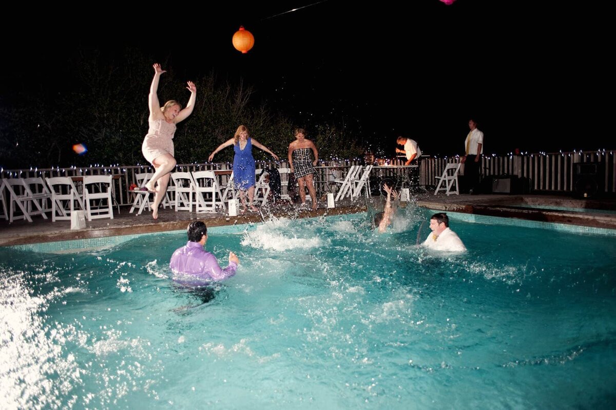 wedding guests jump in a pool after the wedding