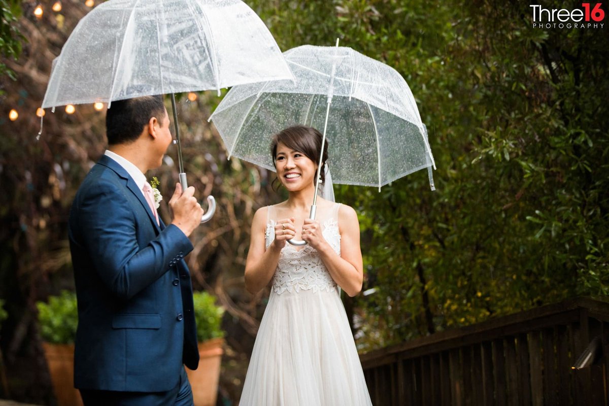 Newly married couple gaze upon each other during a rainfall