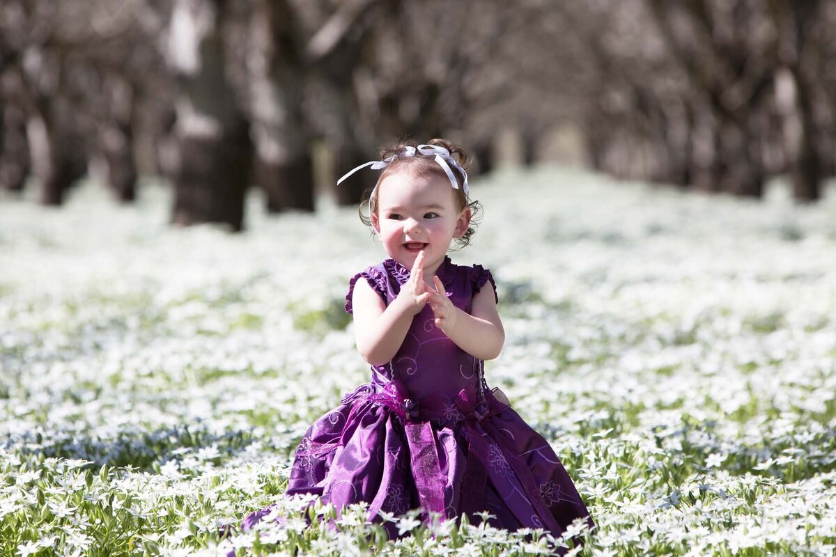 little girl in white flower field