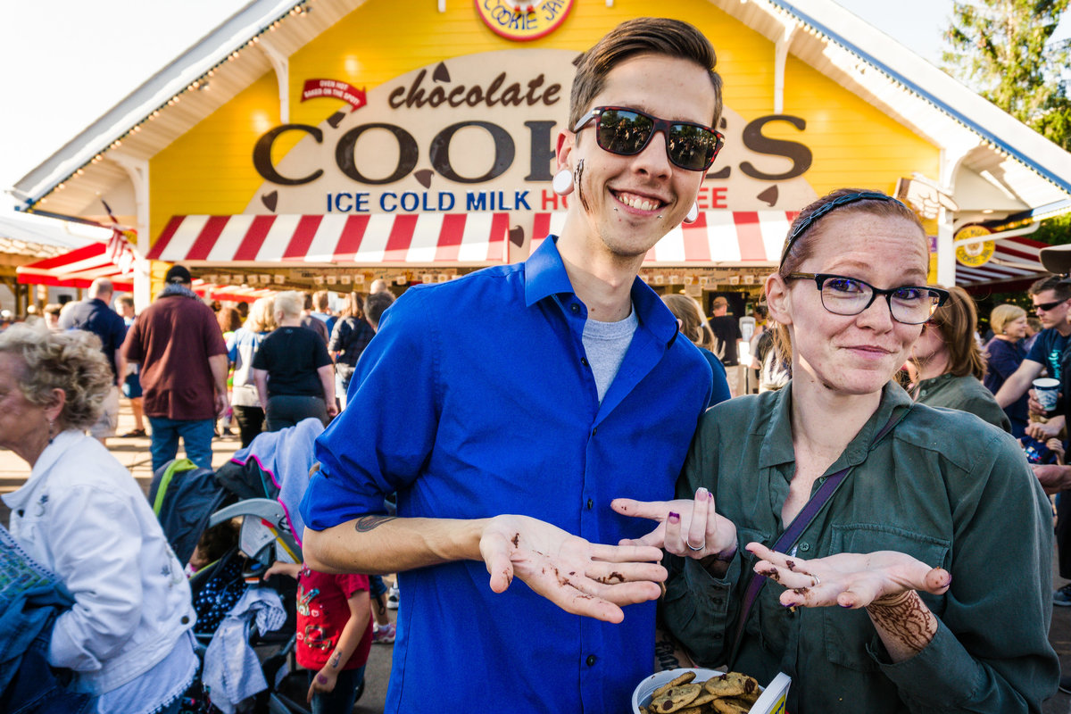 Man and woman are covered in melted chocolate in front of the Sweet Martha's Cookies at the Minnesota State Fair.