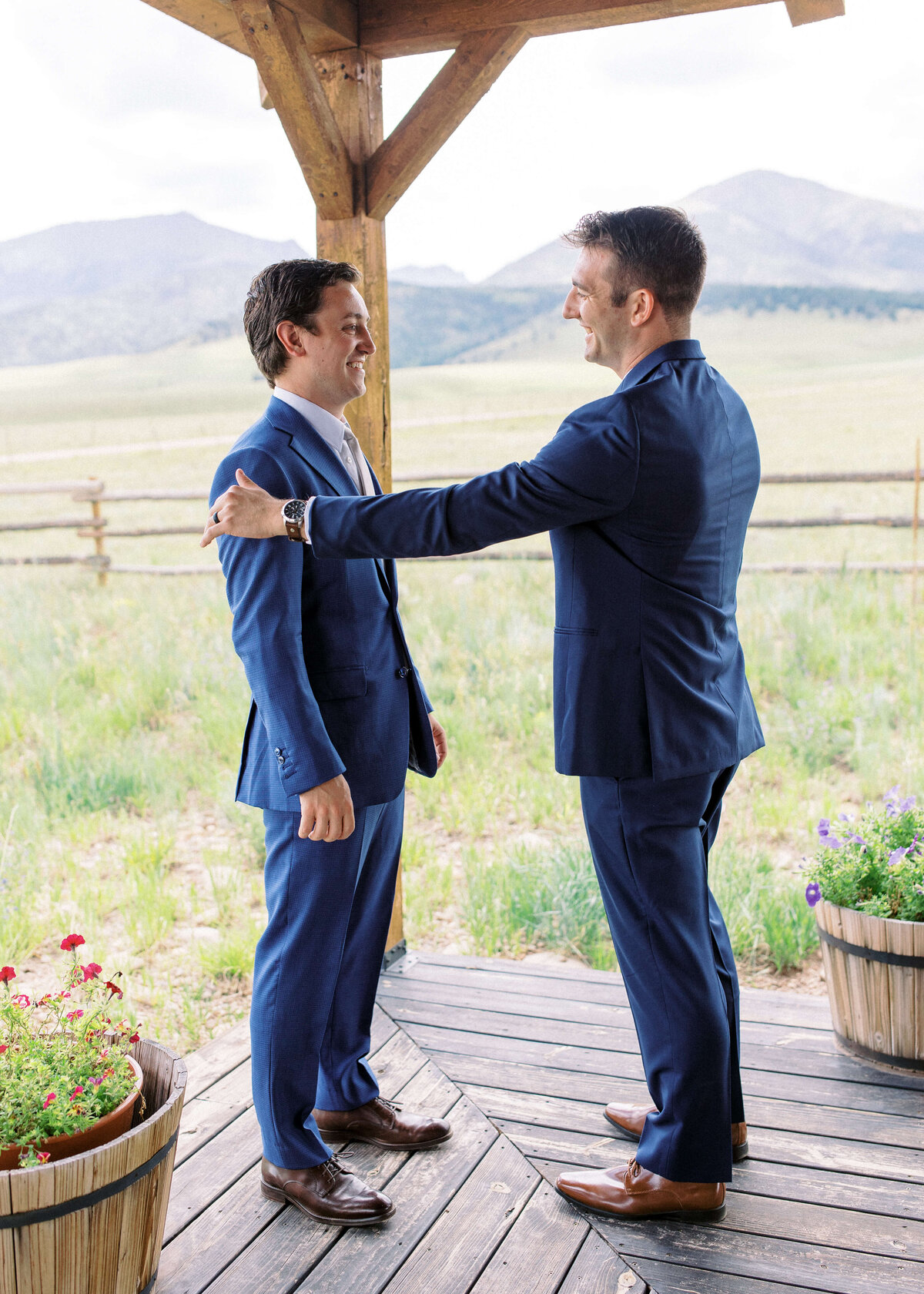 Best man in a navy suit congratulates his best friend, the groom, before the wedding