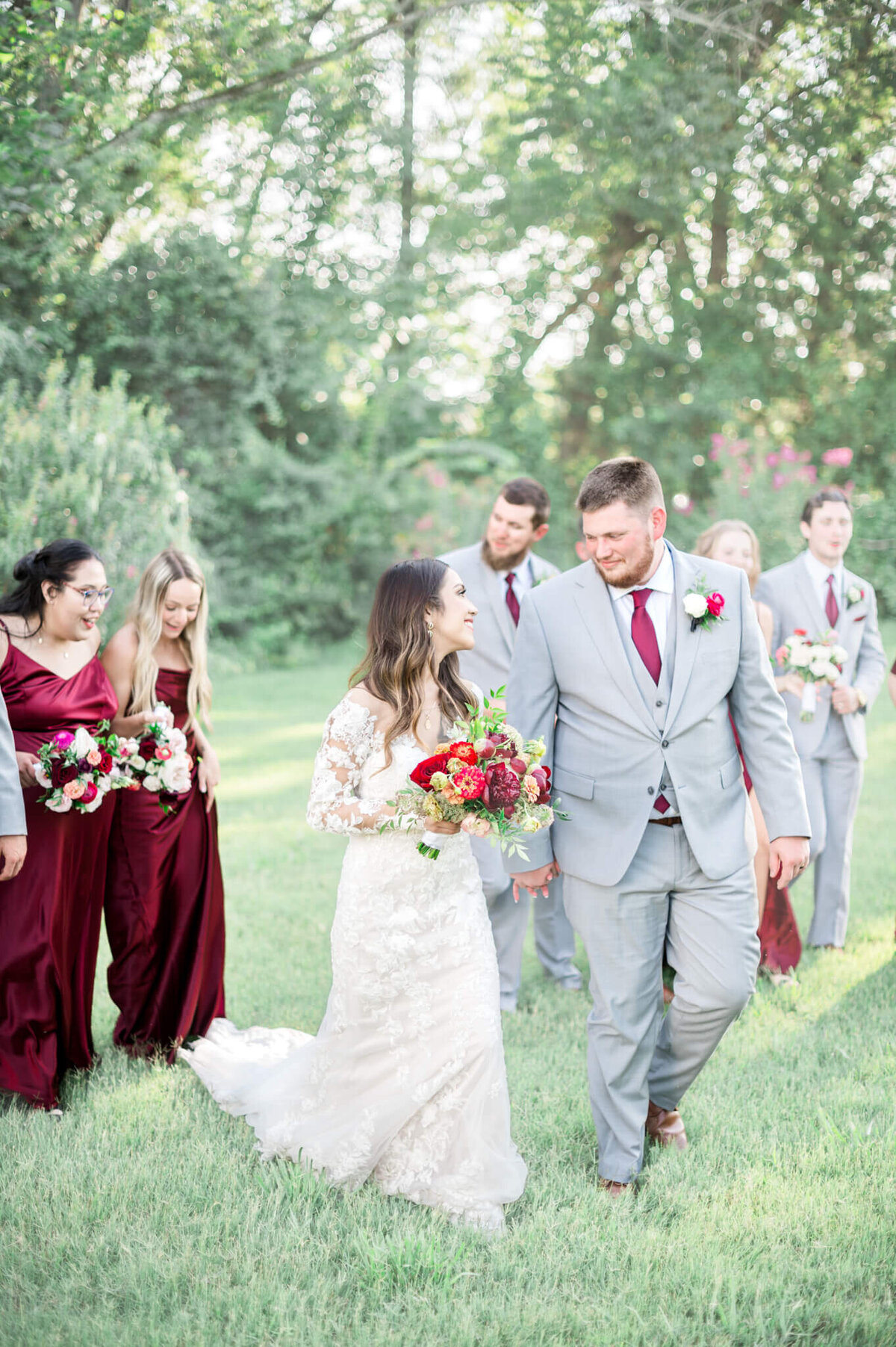 bridal party photo focused on bride and groom while their bridesmaids and groomsmen follow behind