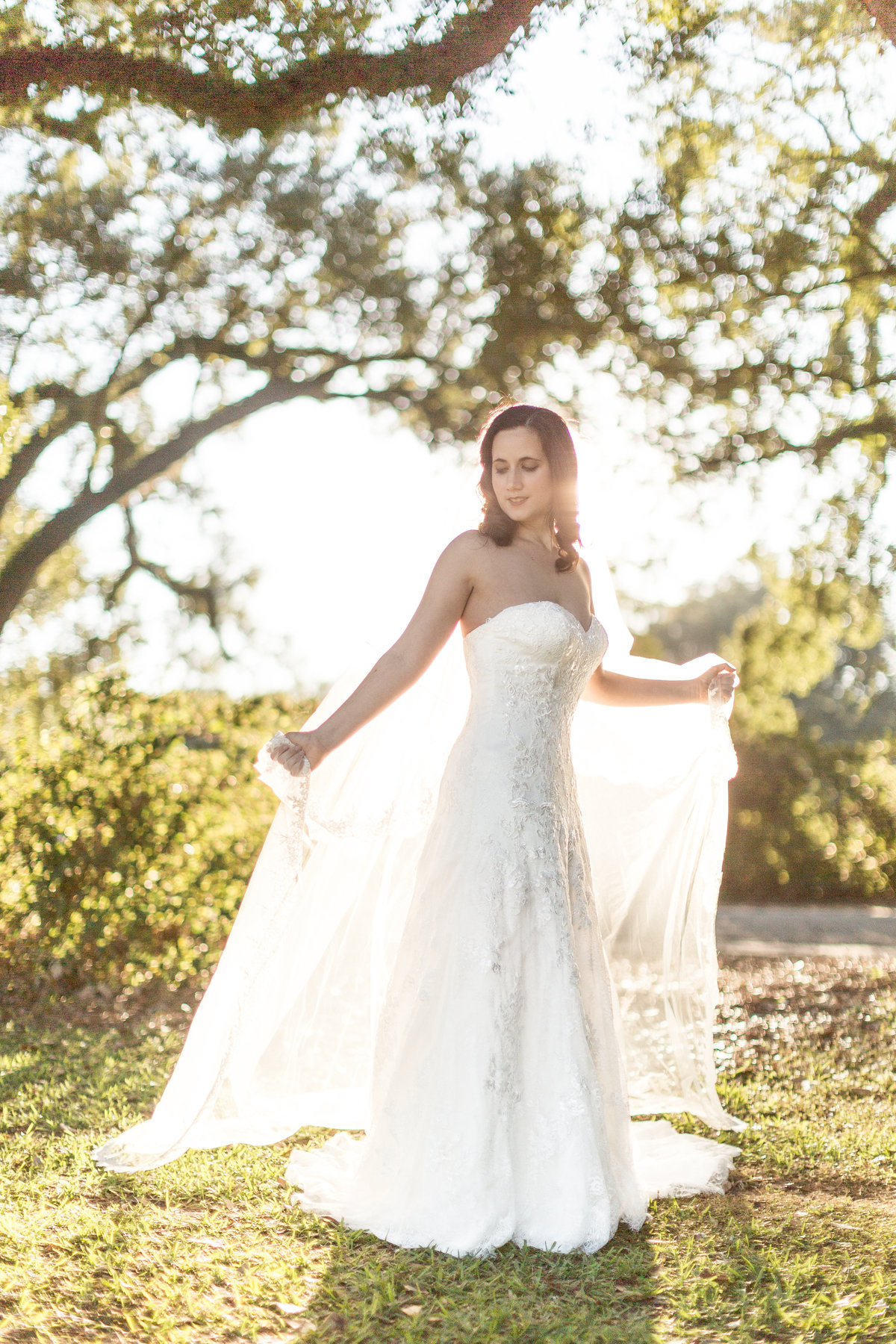 A bride shows off her vail during a portrait session at Springhill College in Mobile, Alabama.