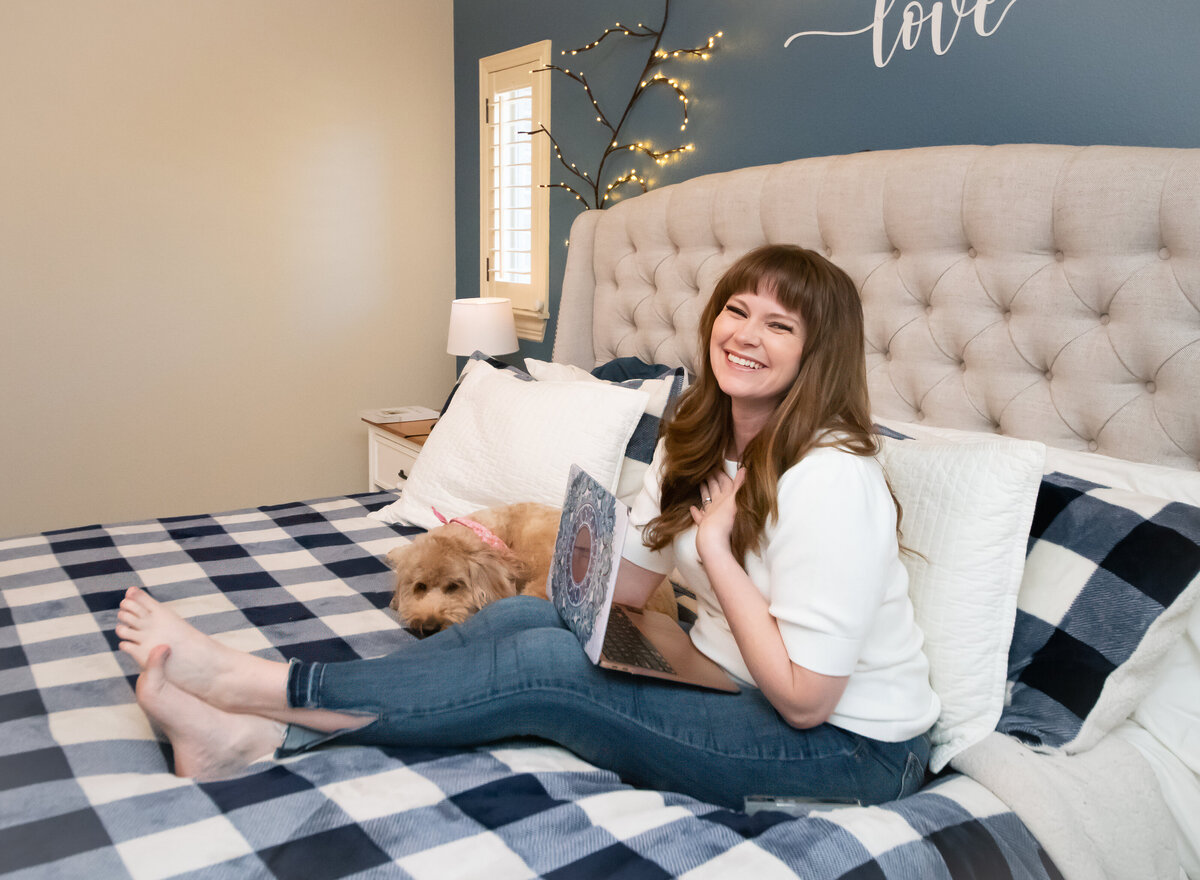 woman who does a podcast sitting on bed with  laptop