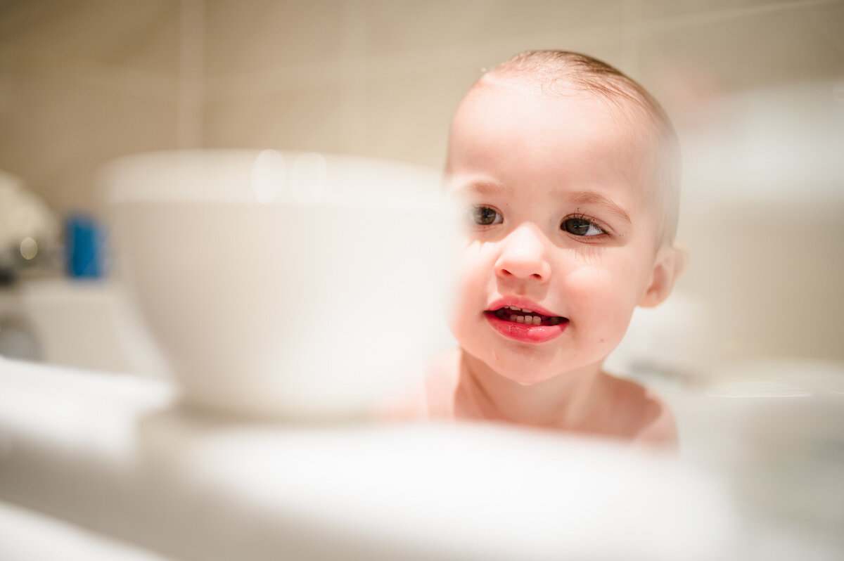 little girl playing tea cups in the bath during family photoshoot
