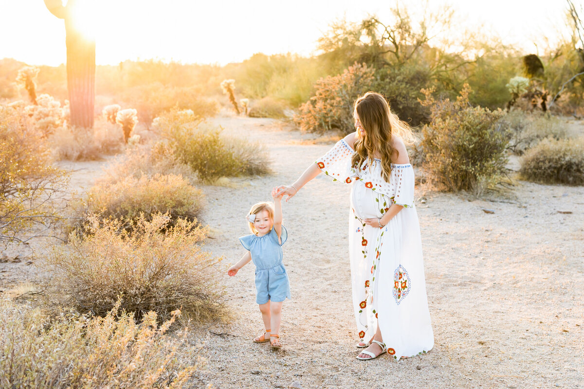pregnant mom and daughter dance in the Scottsdale desert