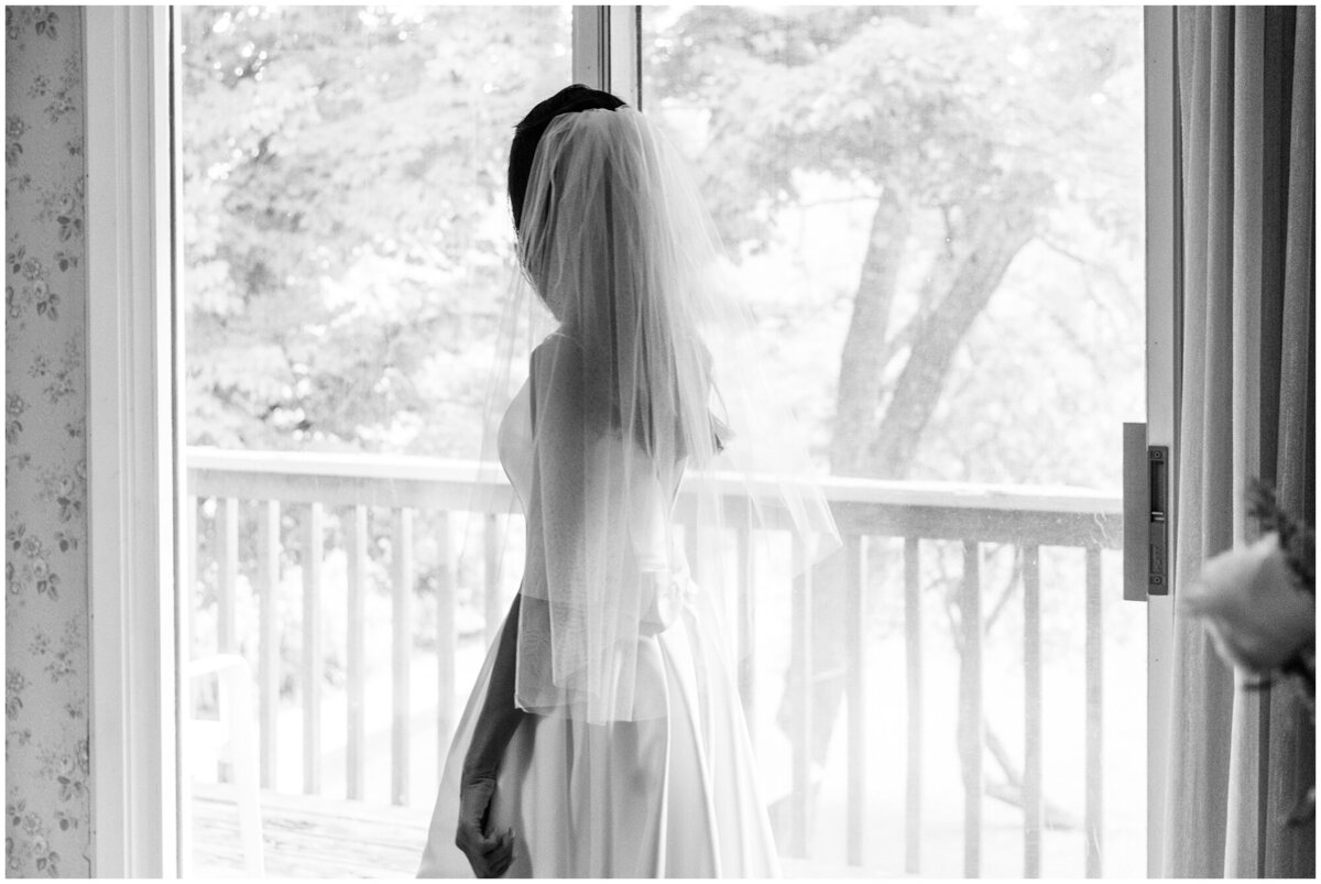 Image of bride looking out through the window just finished getting ready