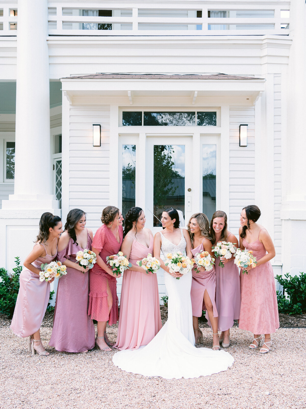 Bride with bridesmaids in varying shades of pink dresses at The Grand Lady Austin Wedding