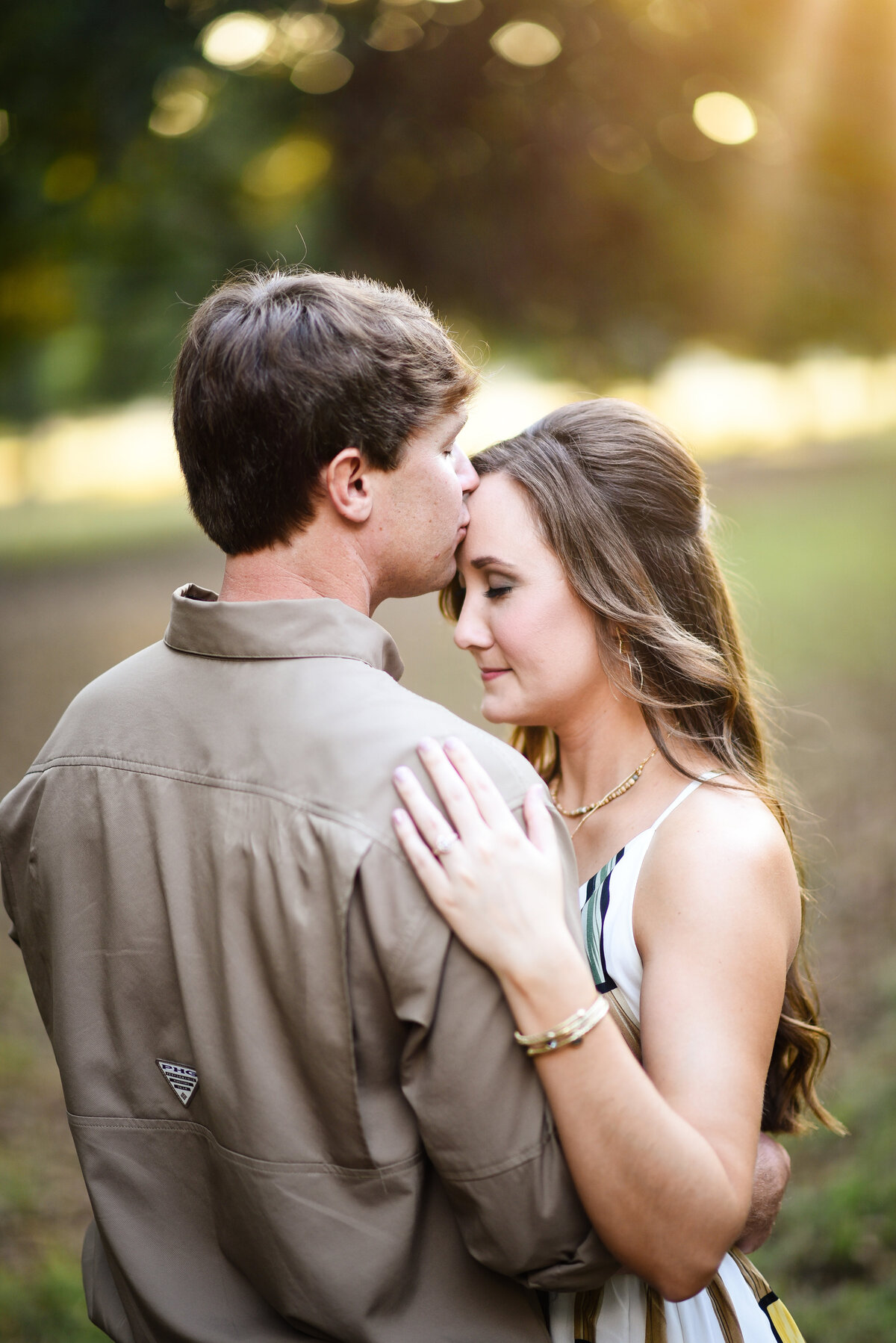 Beautiful Mississippi Engagement Photography: man kisses woman during golden hour sunset in Mississippi Delta Pecan Orchard