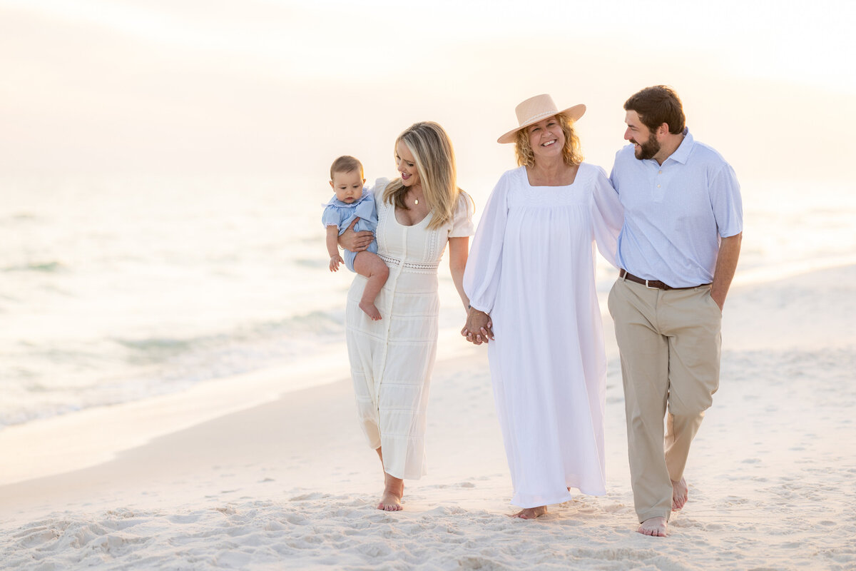 A family holding hands and walking along the beach in  Alys Beach Florida.