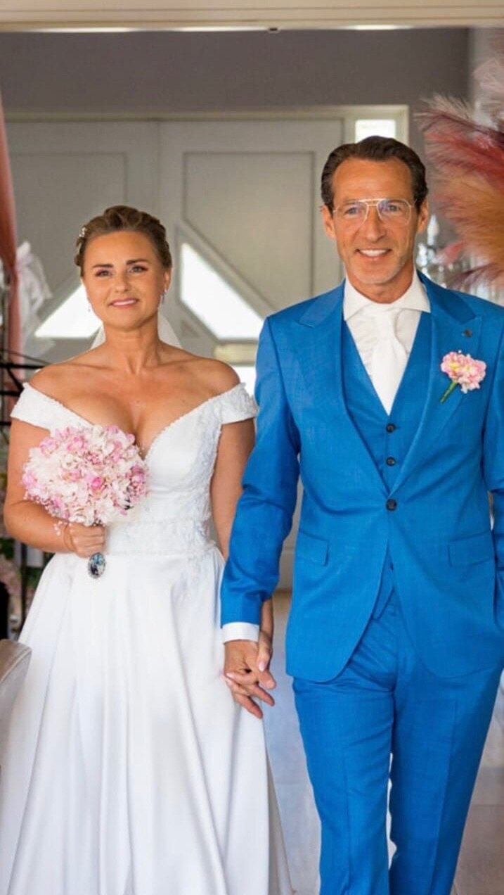 Bruidspaar loopt hand in hand, trots en stralend tijdens hun bruiloft, professioneel begeleid door weddingplanner