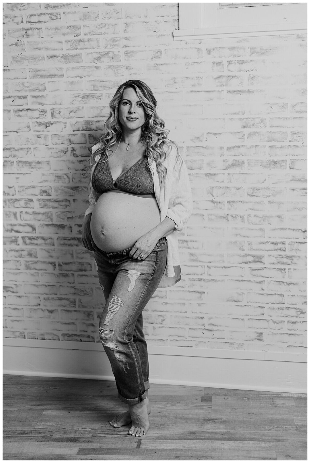 Mom to be showing off her beautiful baby bump in a cute top and jeans during a maternity photoshoot in studio in Wexford PA