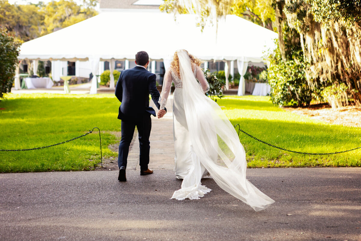 Bride and groom walk to their Legare Waring House Reception Charleston Wedding Photographer